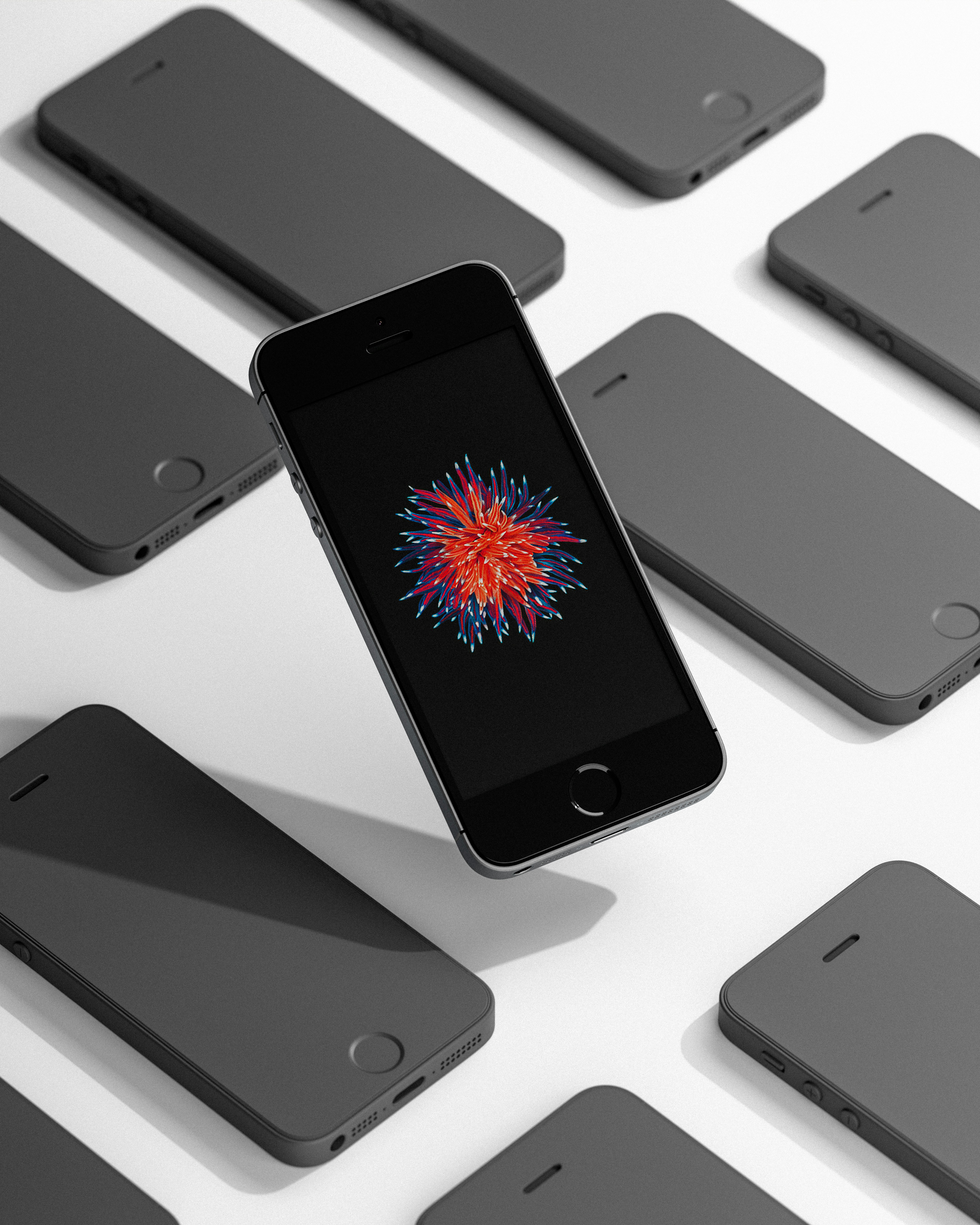 A black phone surrounded by others on a white surface.