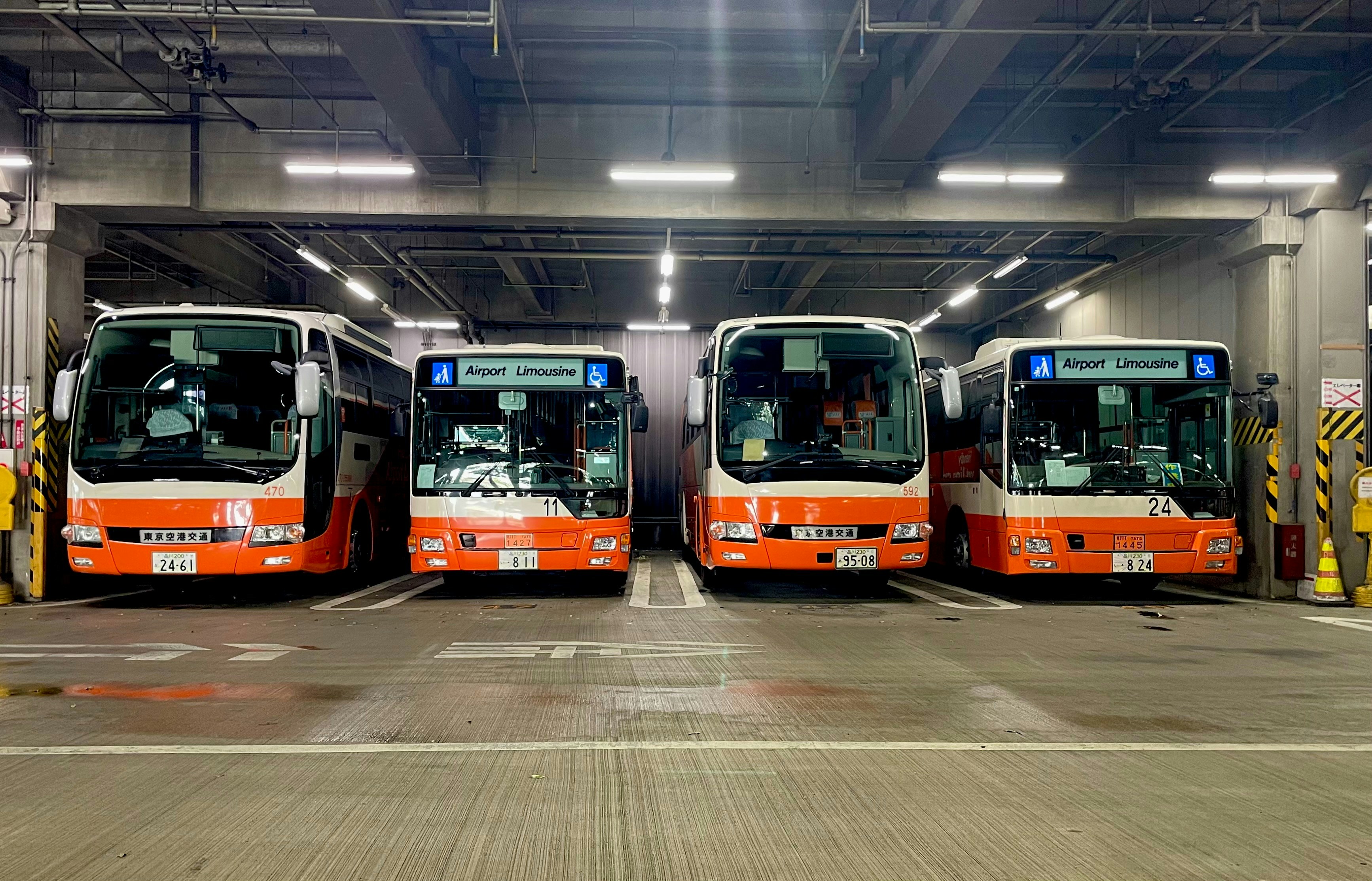 Four buses are parked inside a garage. photo – Free Human Image on Unsplash
