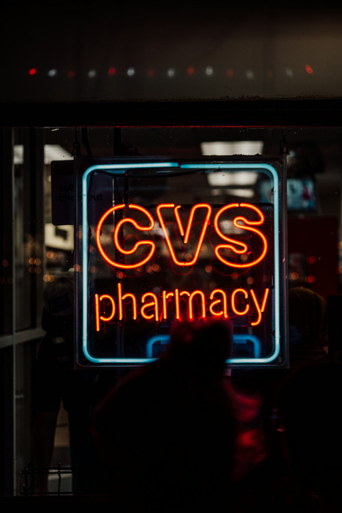 A CVS pharmacy sign glowing at night on a city street