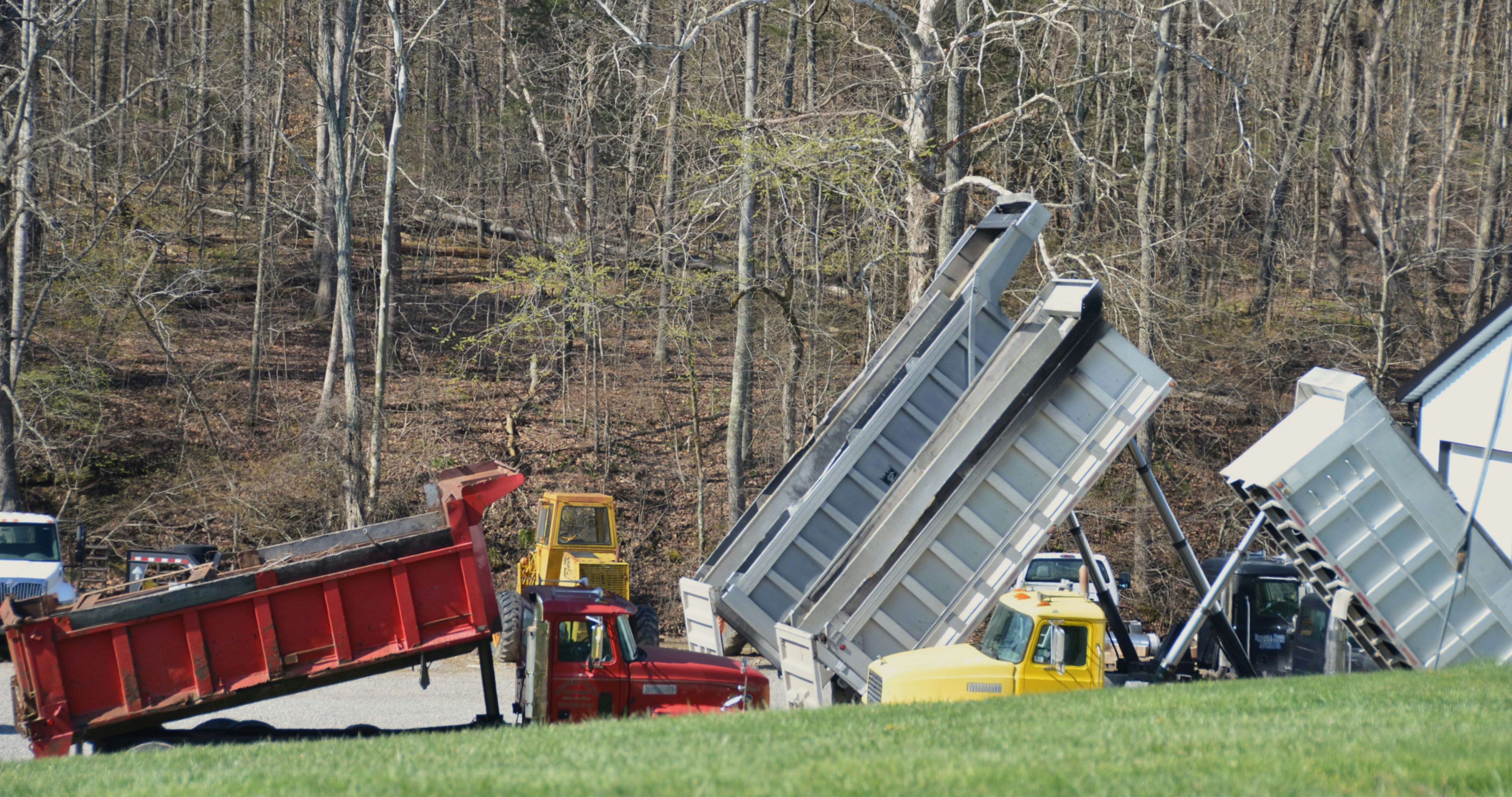 Dump trucks are tipped over on the grass. photo – Free Car Image on ...
