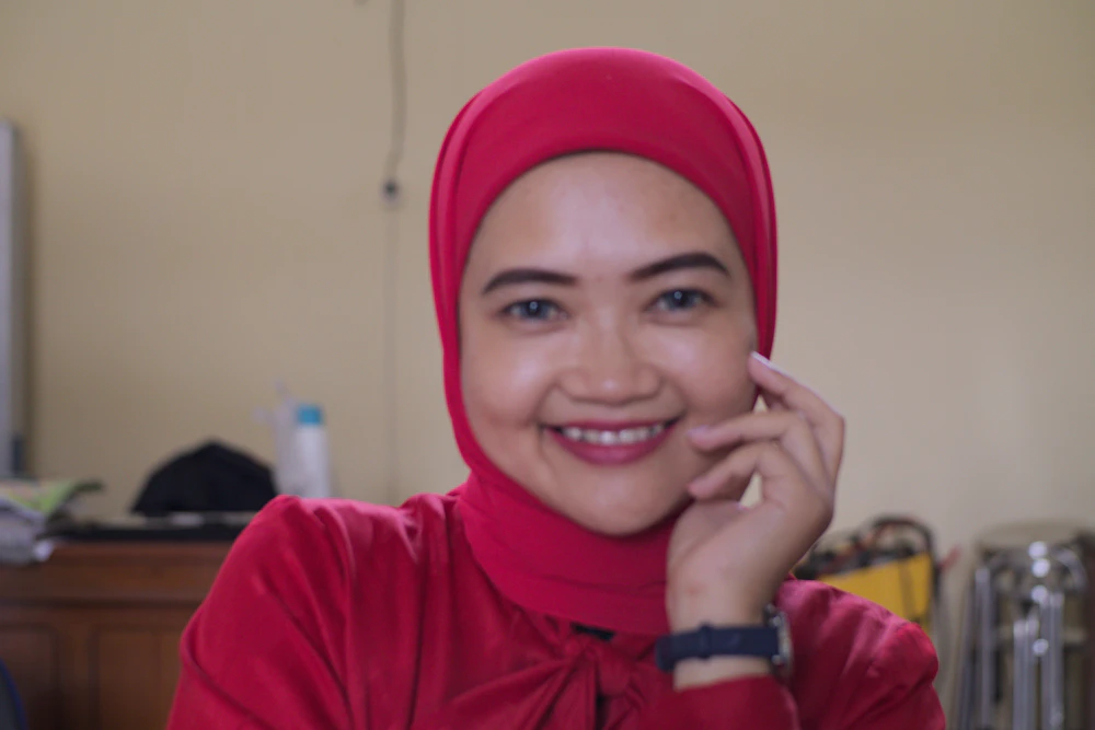 A woman in a red hijab smiling