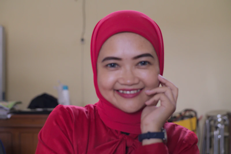 Smiling woman wearing a red hijab.
