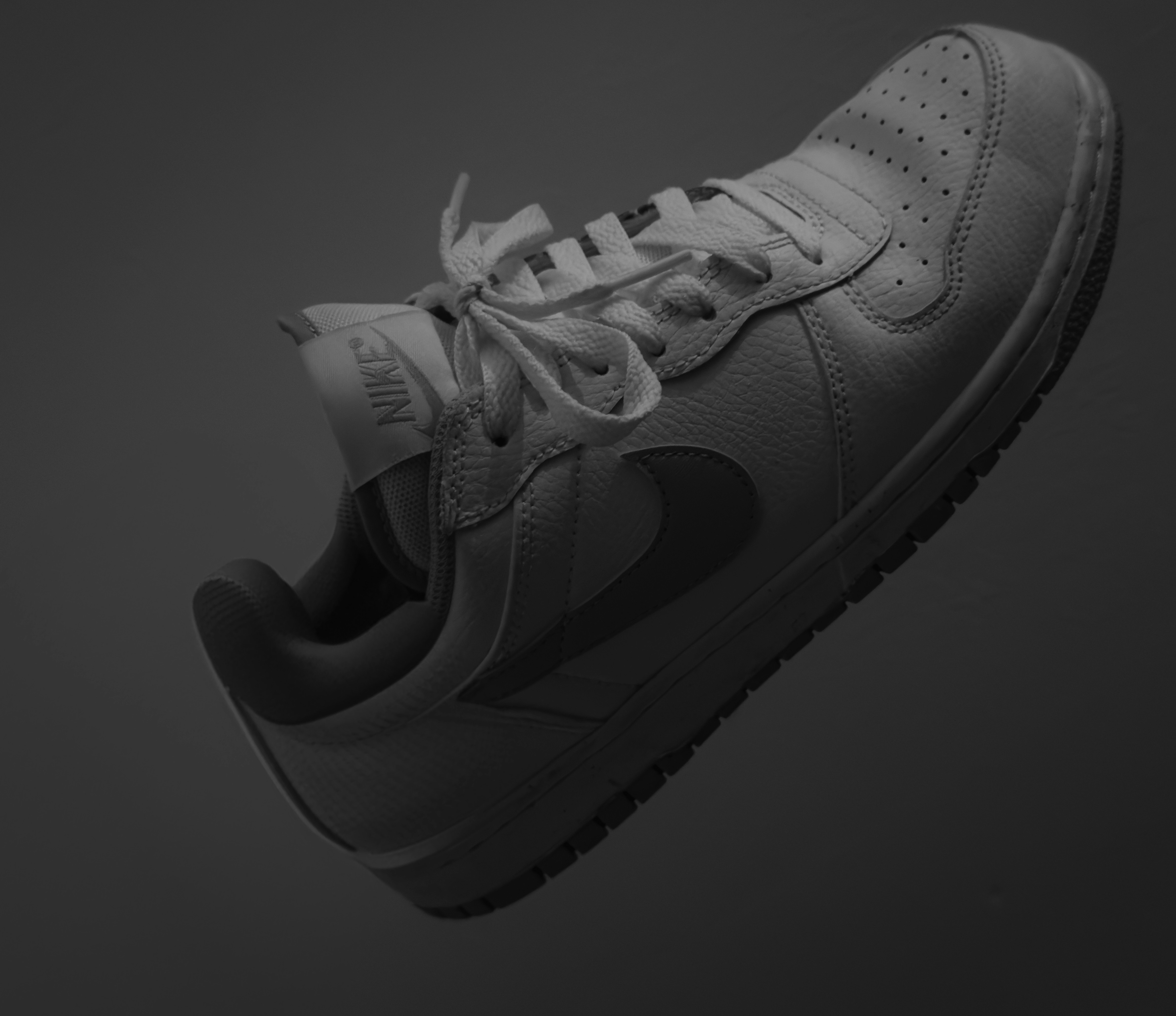A white nike shoe pictured in monochrome.
