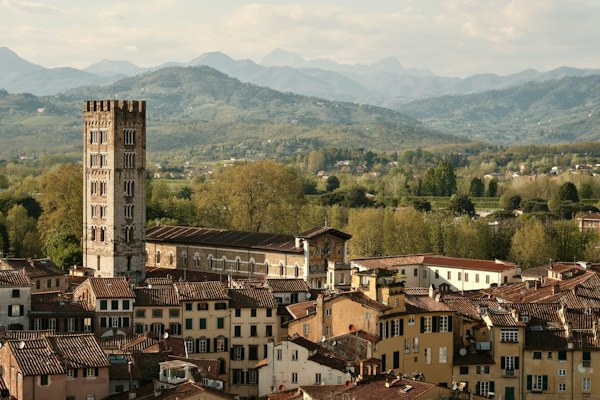 A tower and buildings overlook the italian landscape — Lucca, Italy