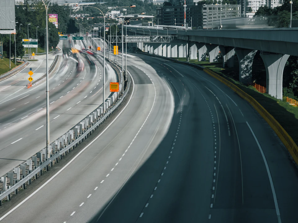 Highway with multiple lanes, including one empty and one congested with vehicles nearby