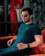 A man is stylishly posing on a couch.