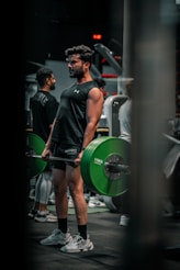 Man lifts weights in a gym environment.