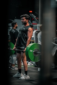 Man lifts weights in a gym environment.