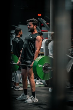 Man lifts weights in a gym environment.