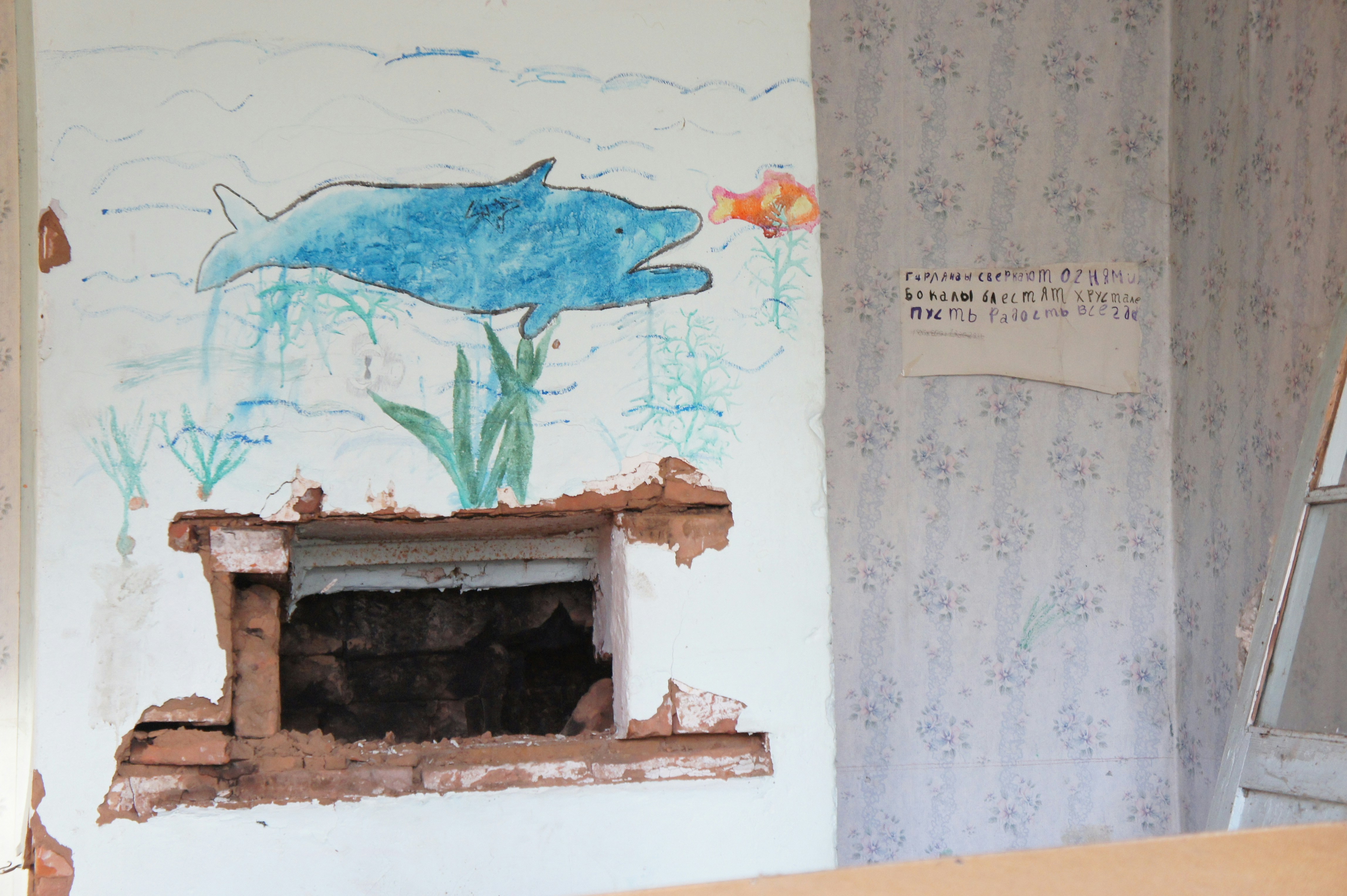 A wall painting depicts a dolphin in the sea.