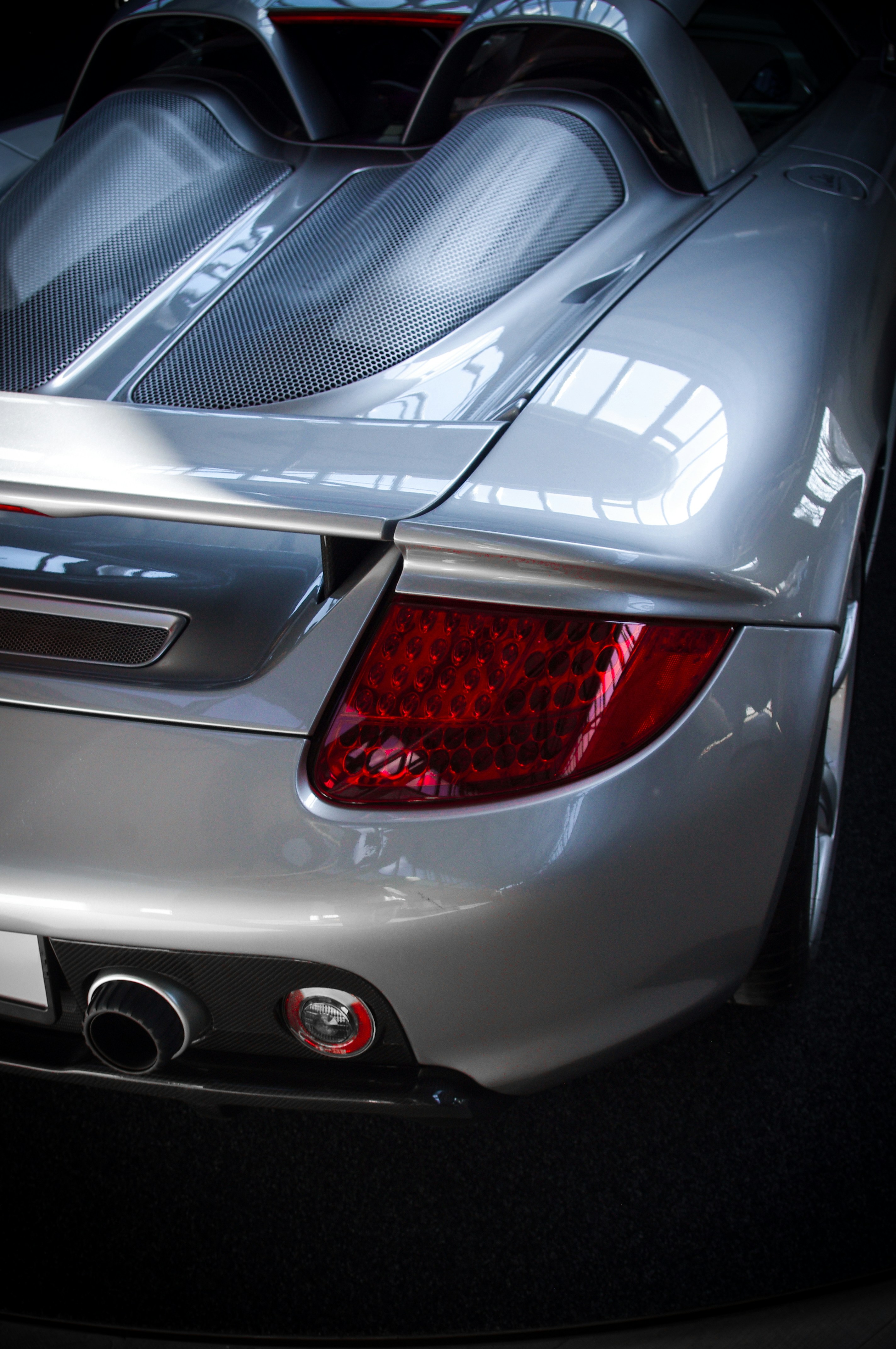 Silver sports car's tail end and taillight.