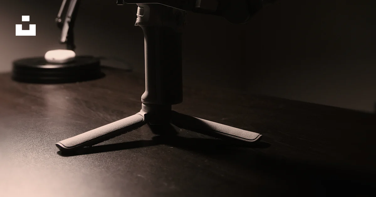 A camera gimbal and lamp sit in dim light. photo – Free Camera Image on ...