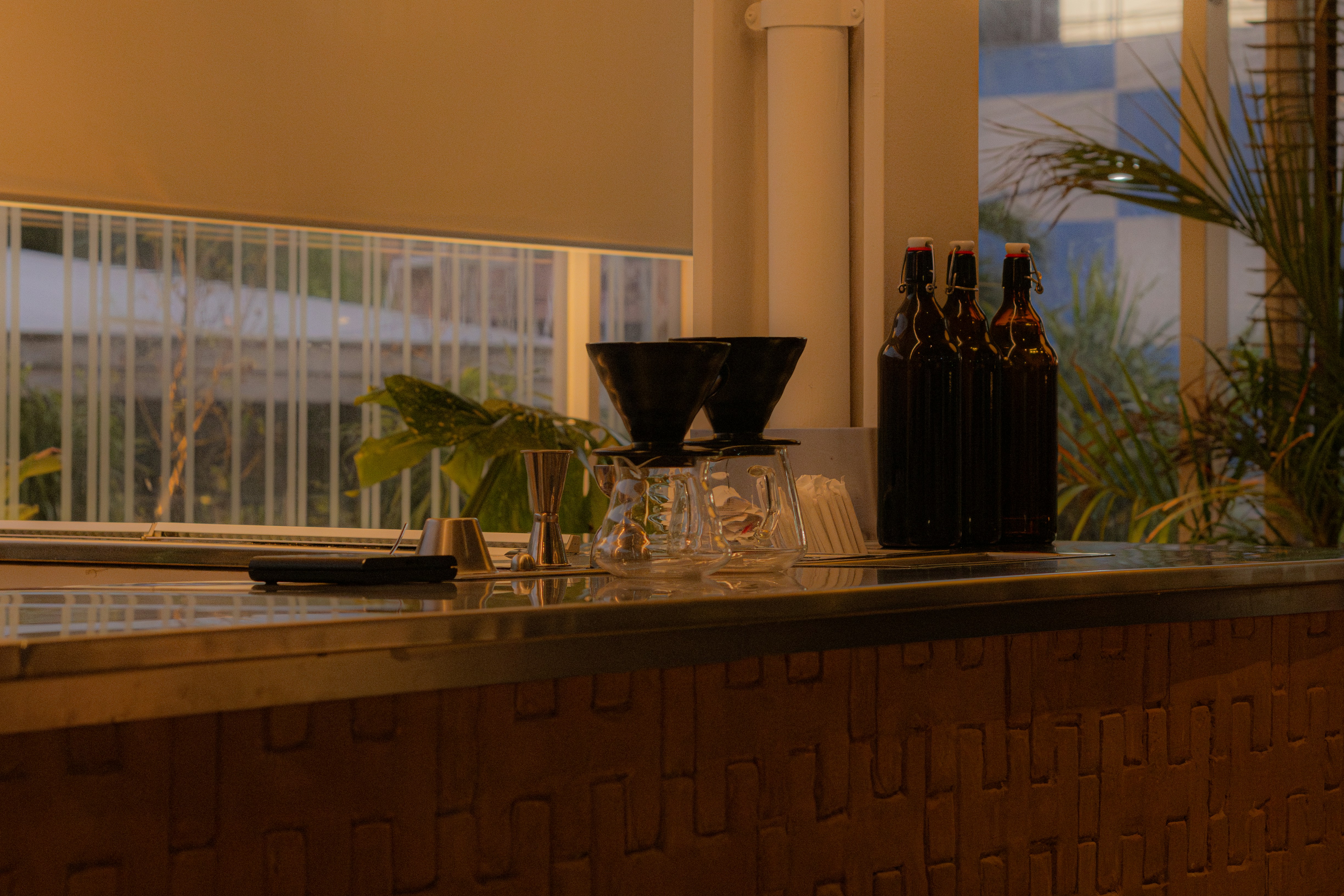 Coffee equipment and bottles sit on a counter.
