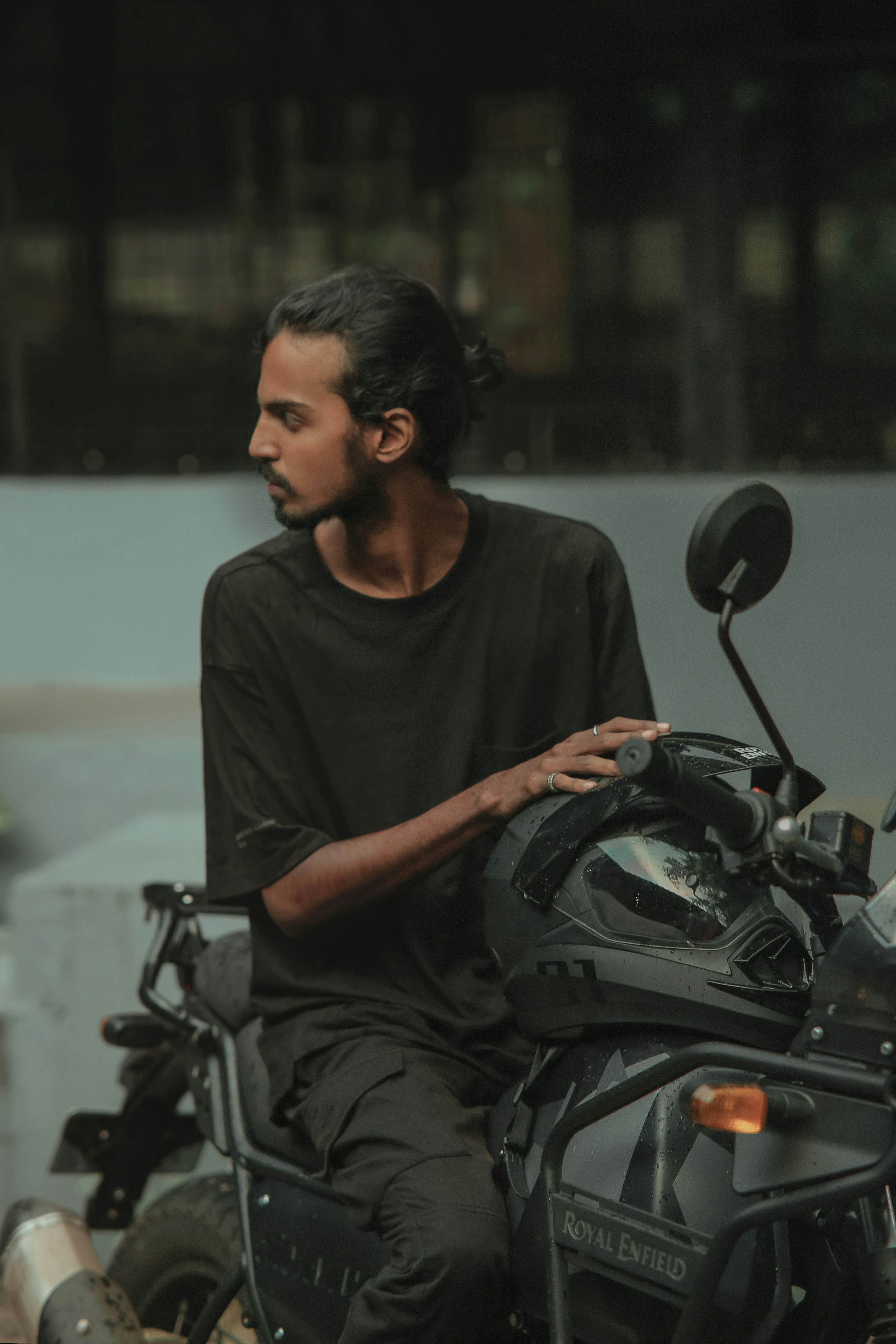 A man poses with his motorcycle.