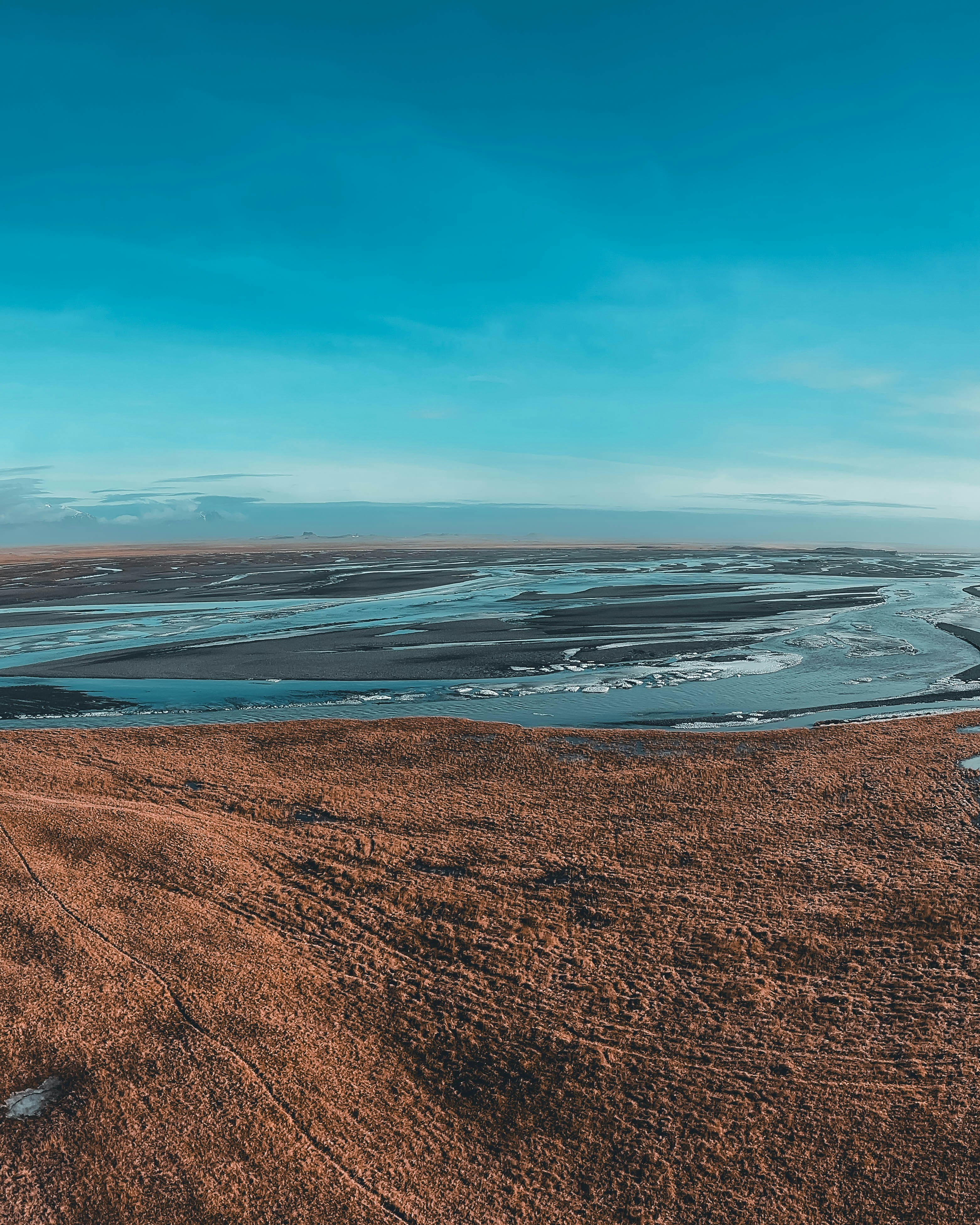 Un hermoso paisaje con un río bajo un cielo azul.