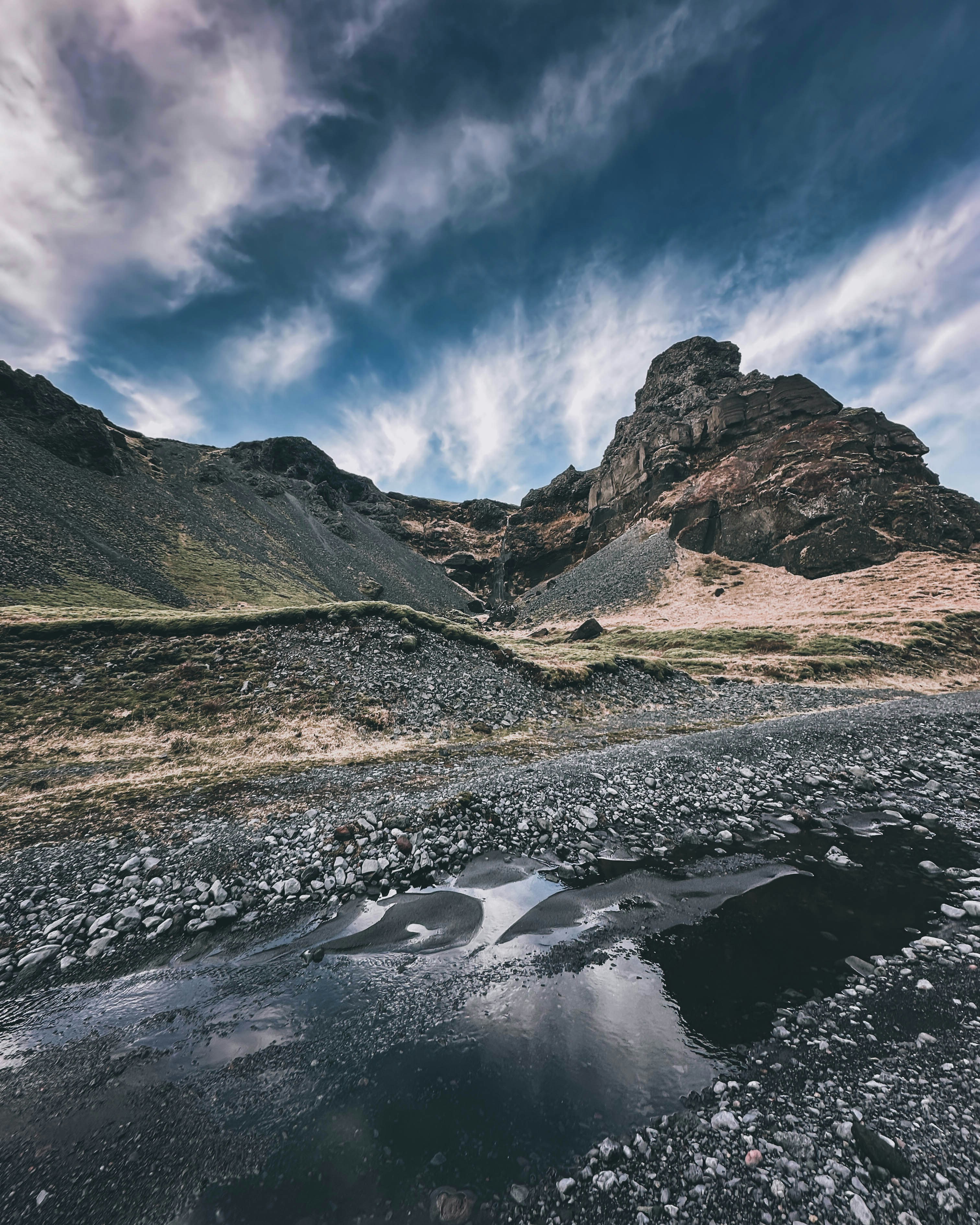 Montañas y agua bajo un cielo llamativo y nublado.