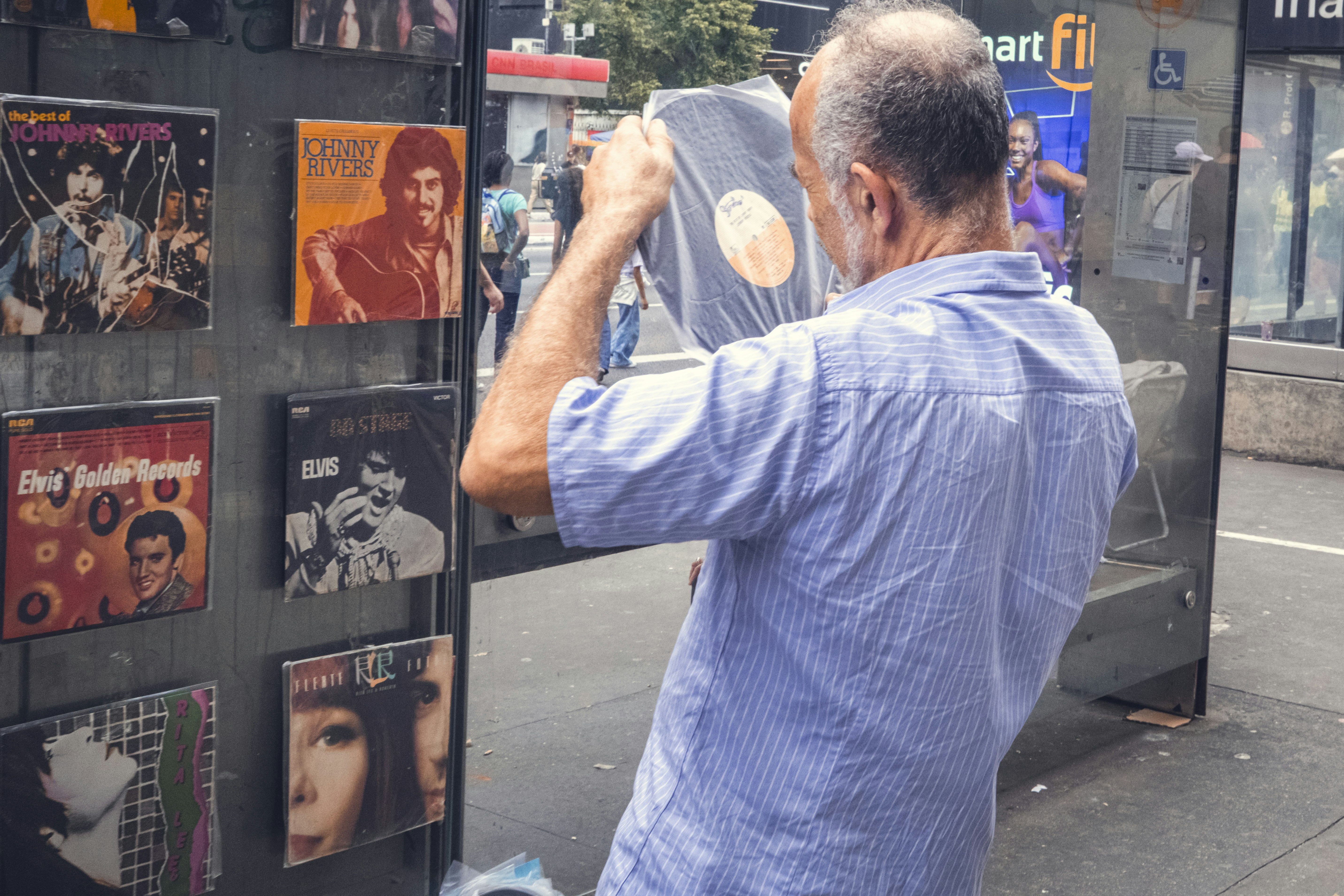 How to Spot a Fake Celebrity Autograph: 6 Red Flags Collectors Miss – A man browses records outside of a store.