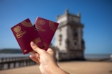 Holding two portuguese passports with a tower.
