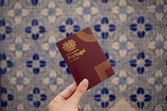 A hand holds a portuguese passport.