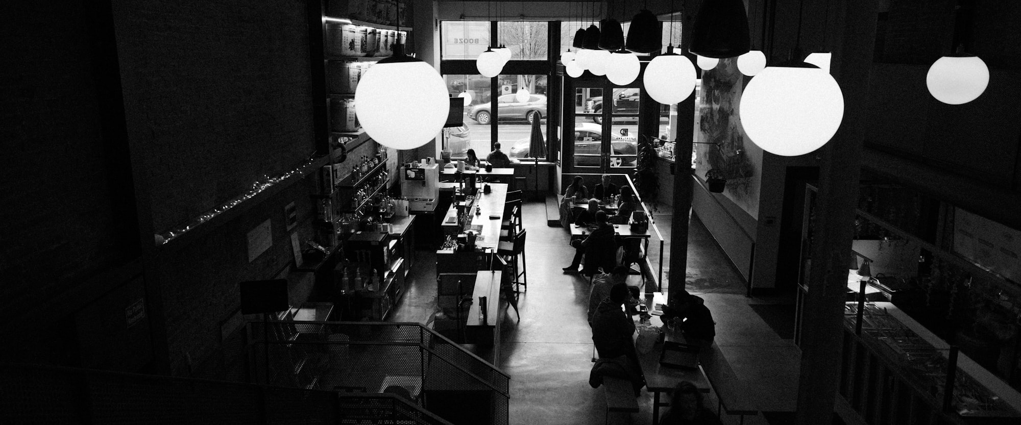 Sala da pranzo in bianco e nero, lampade a globo accese nel buio