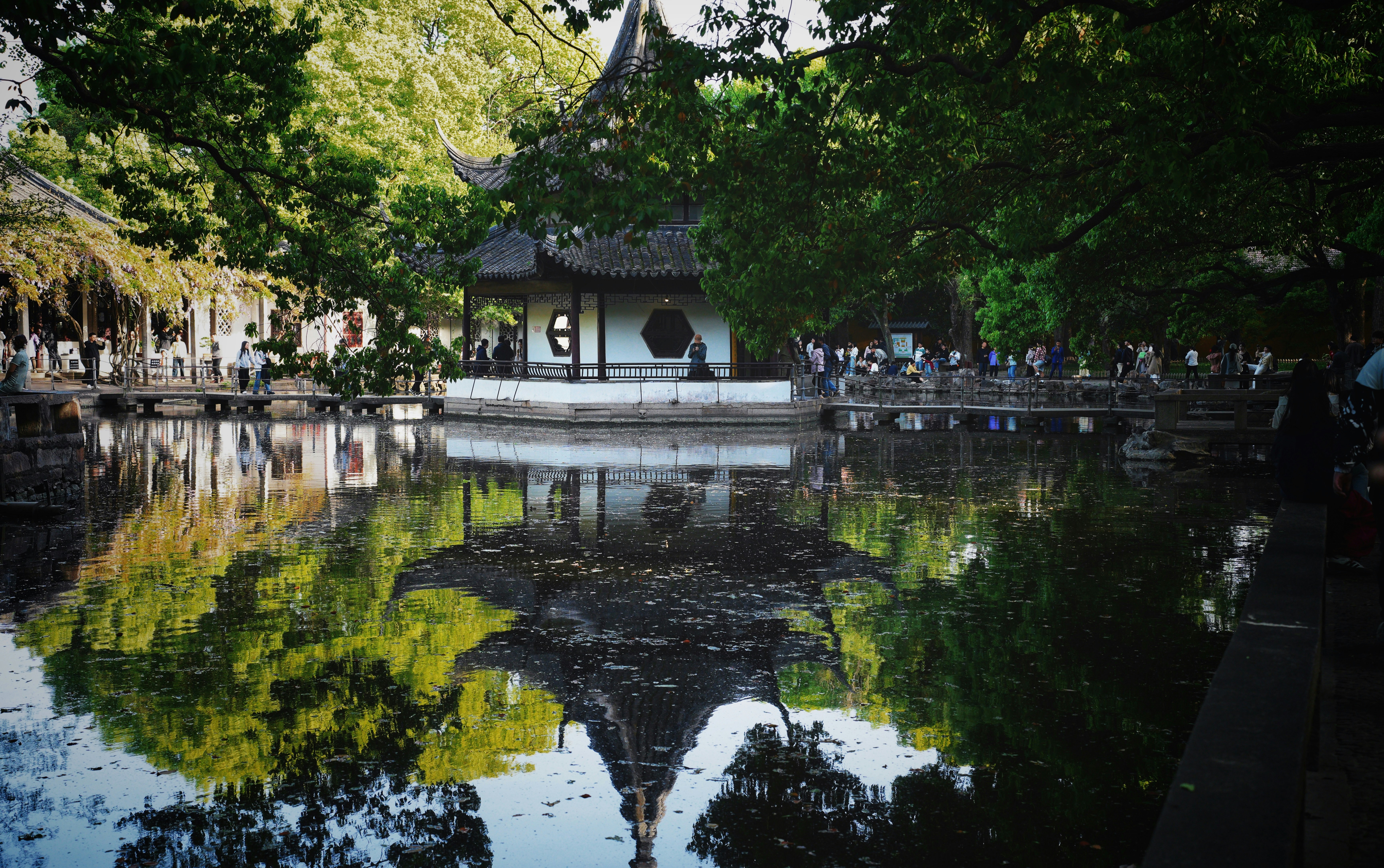 A temple and trees reflect in the tranquil lake.