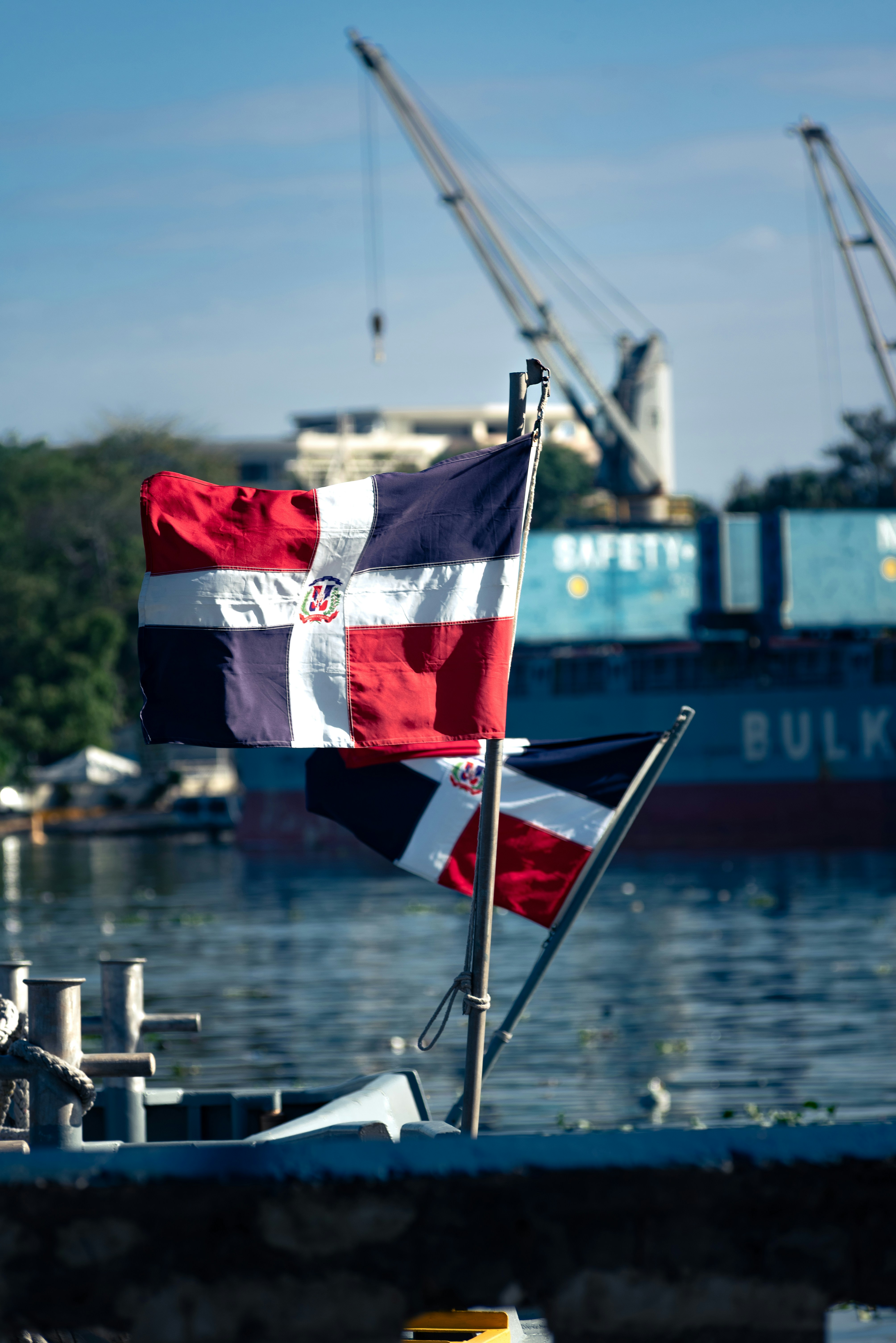 Dominican republic flags wave by the water.