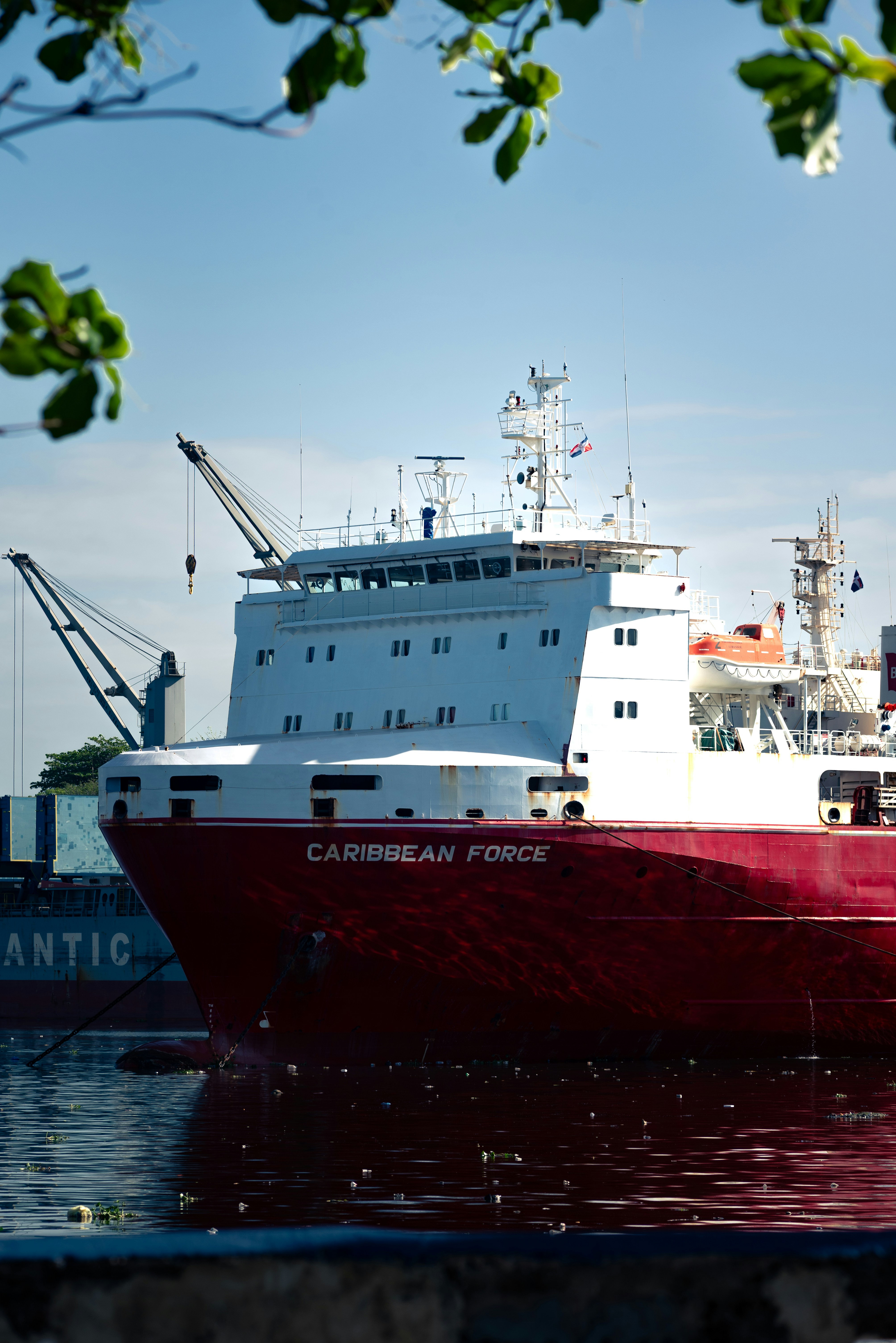 A red ship labeled "caribbean force" is docked.