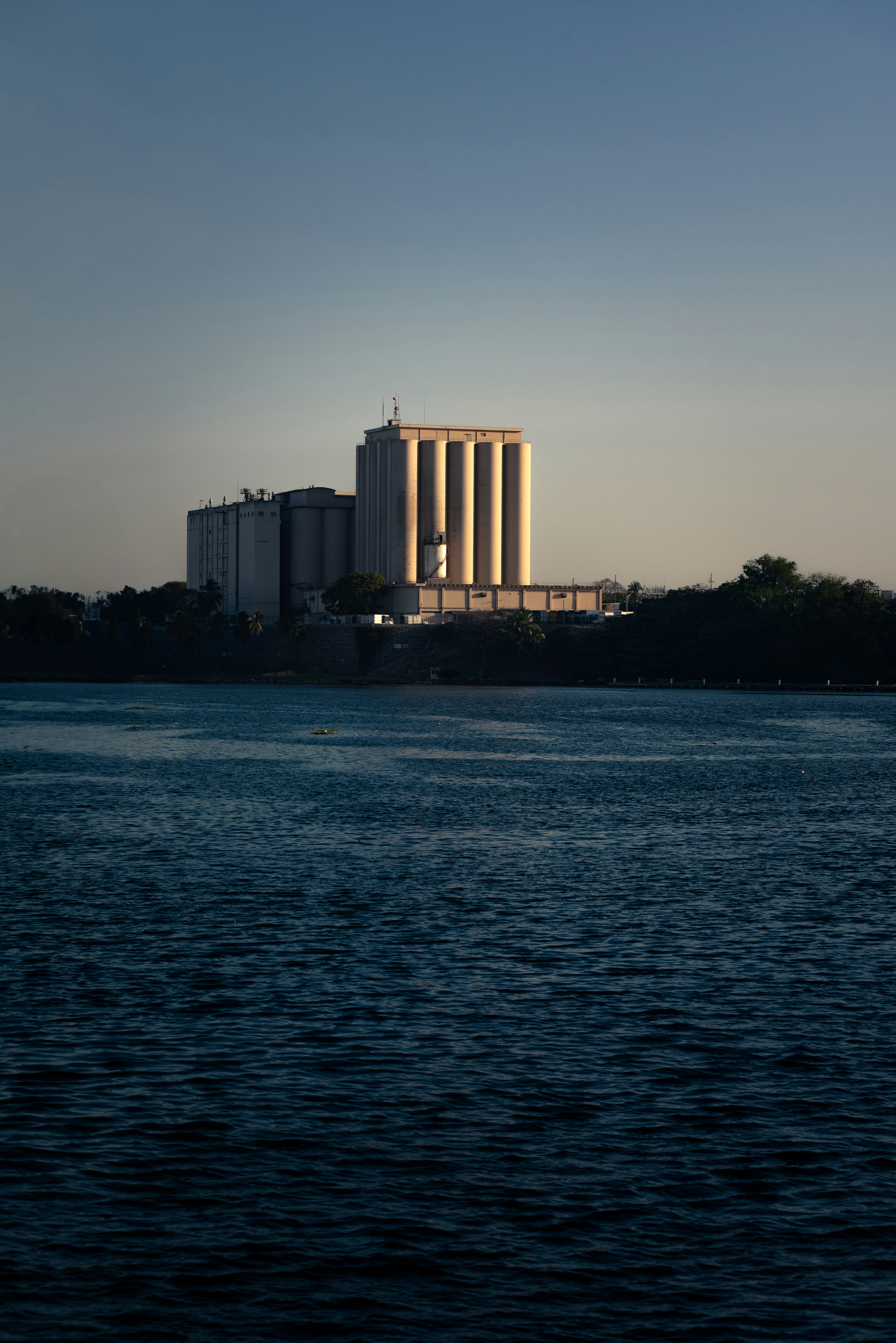 A large building stands near the calm water.