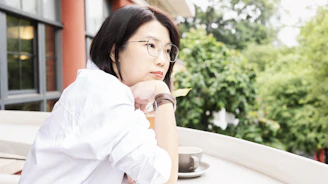 Woman gazes thoughtfully over a natural landscape.
