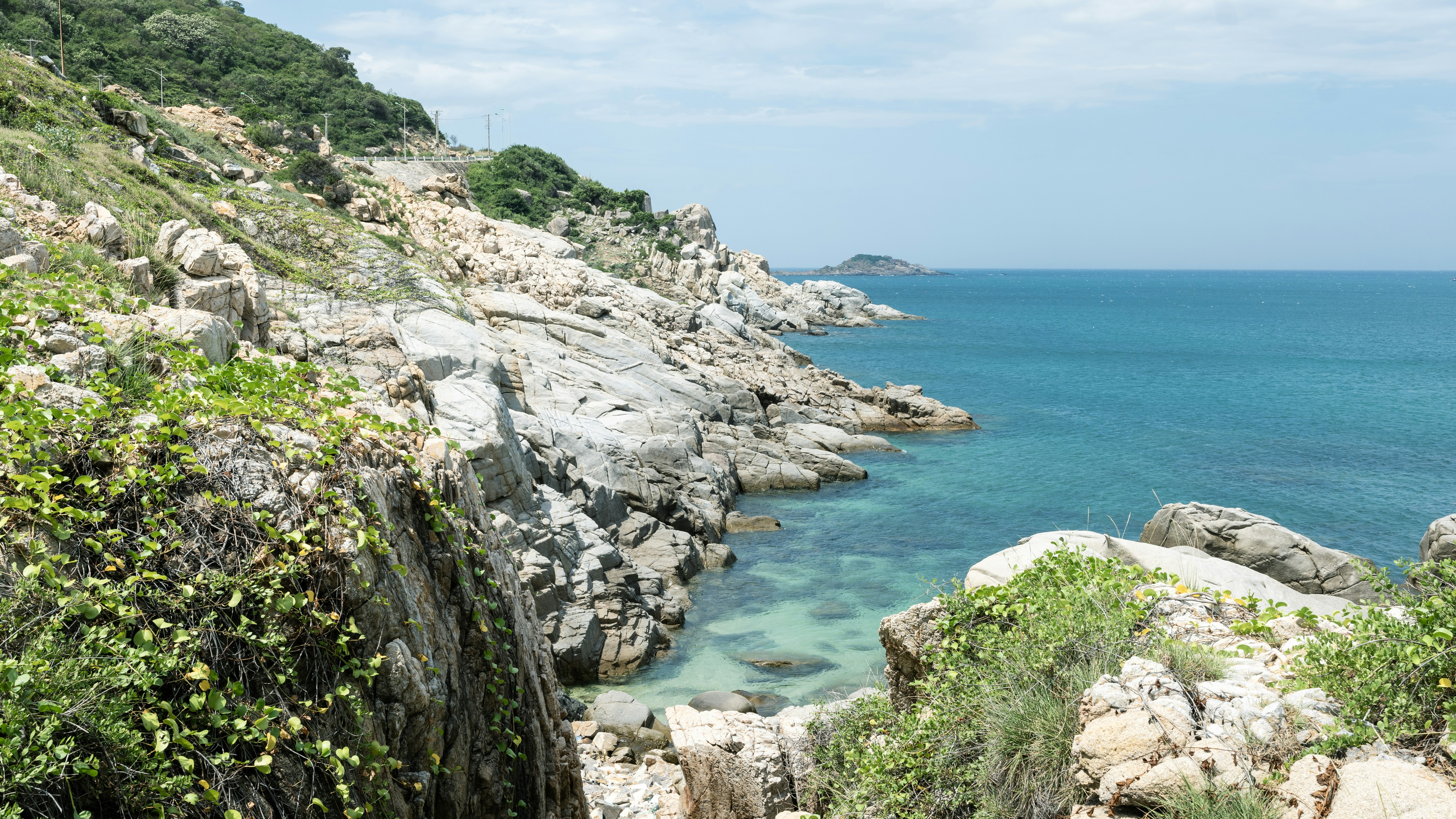 Rocky coast meets clear turquoise ocean water.