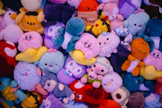 A pile of colorful plushies covers the frame.