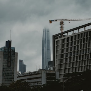Cityscape under a cloudy sky with tall buildings.