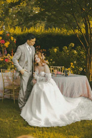 A bride and groom pose by a beautifully decorated table.