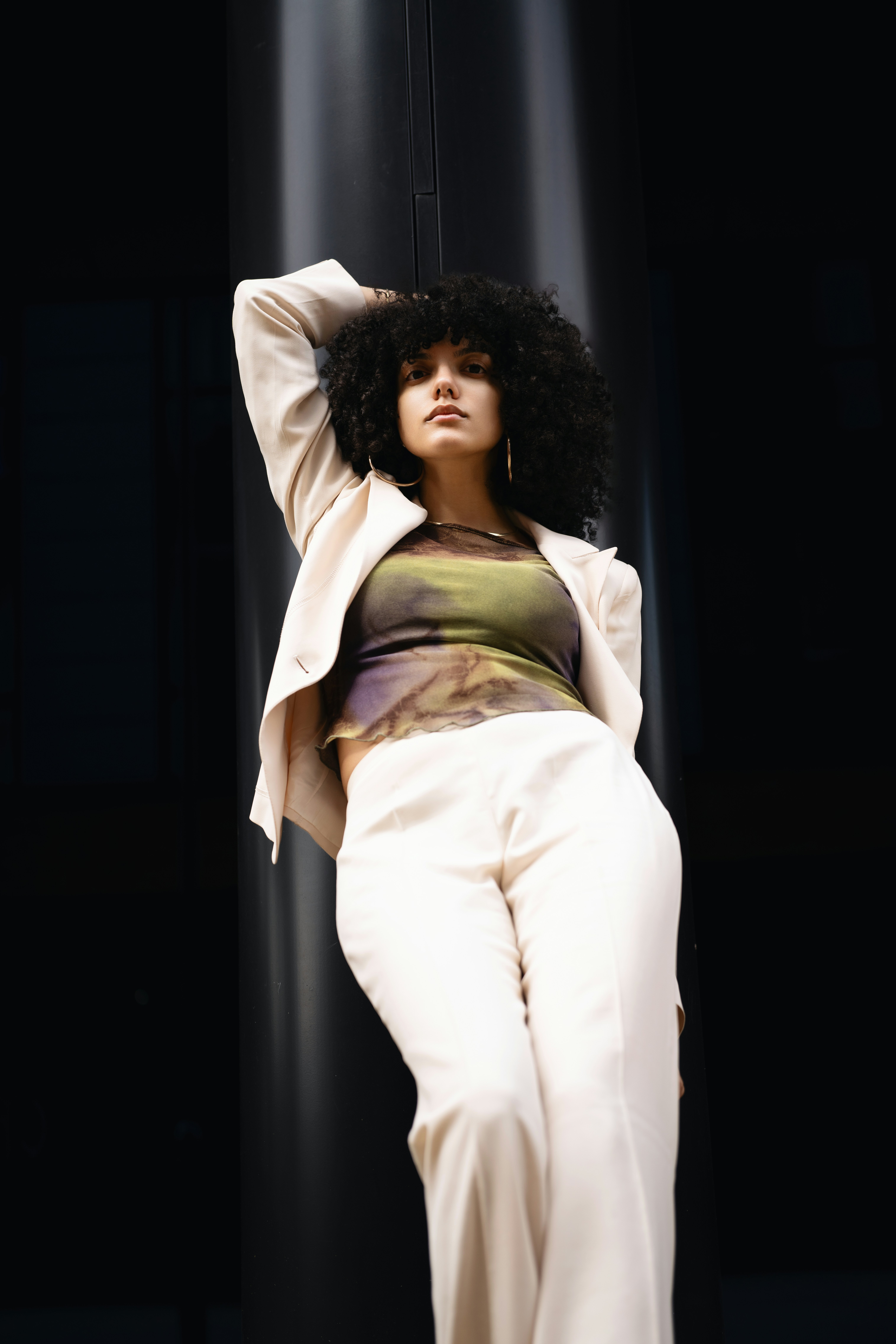 A stylish woman poses in fashionable clothes.