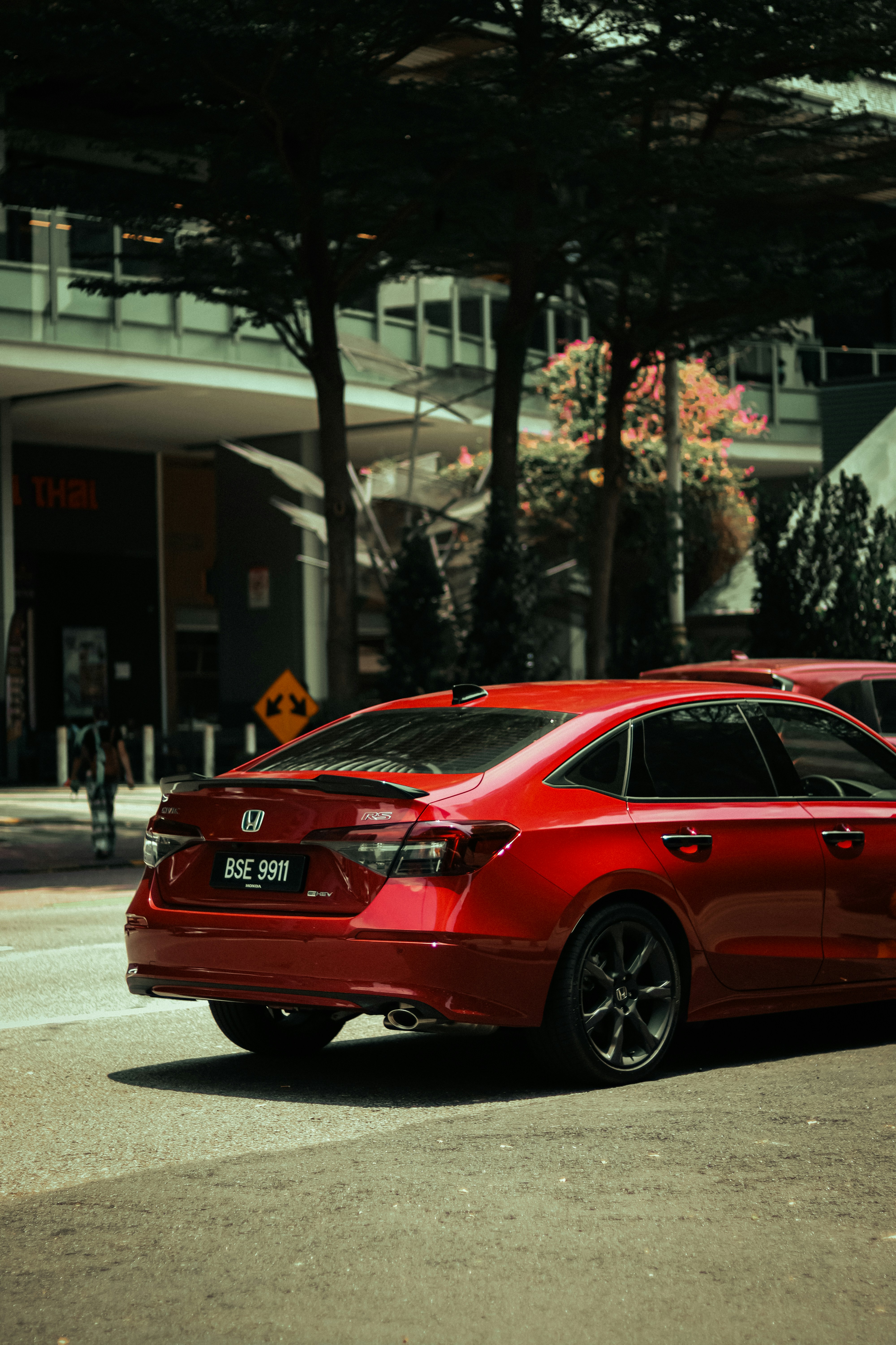 Une voiture rouge est garée dans la rue.