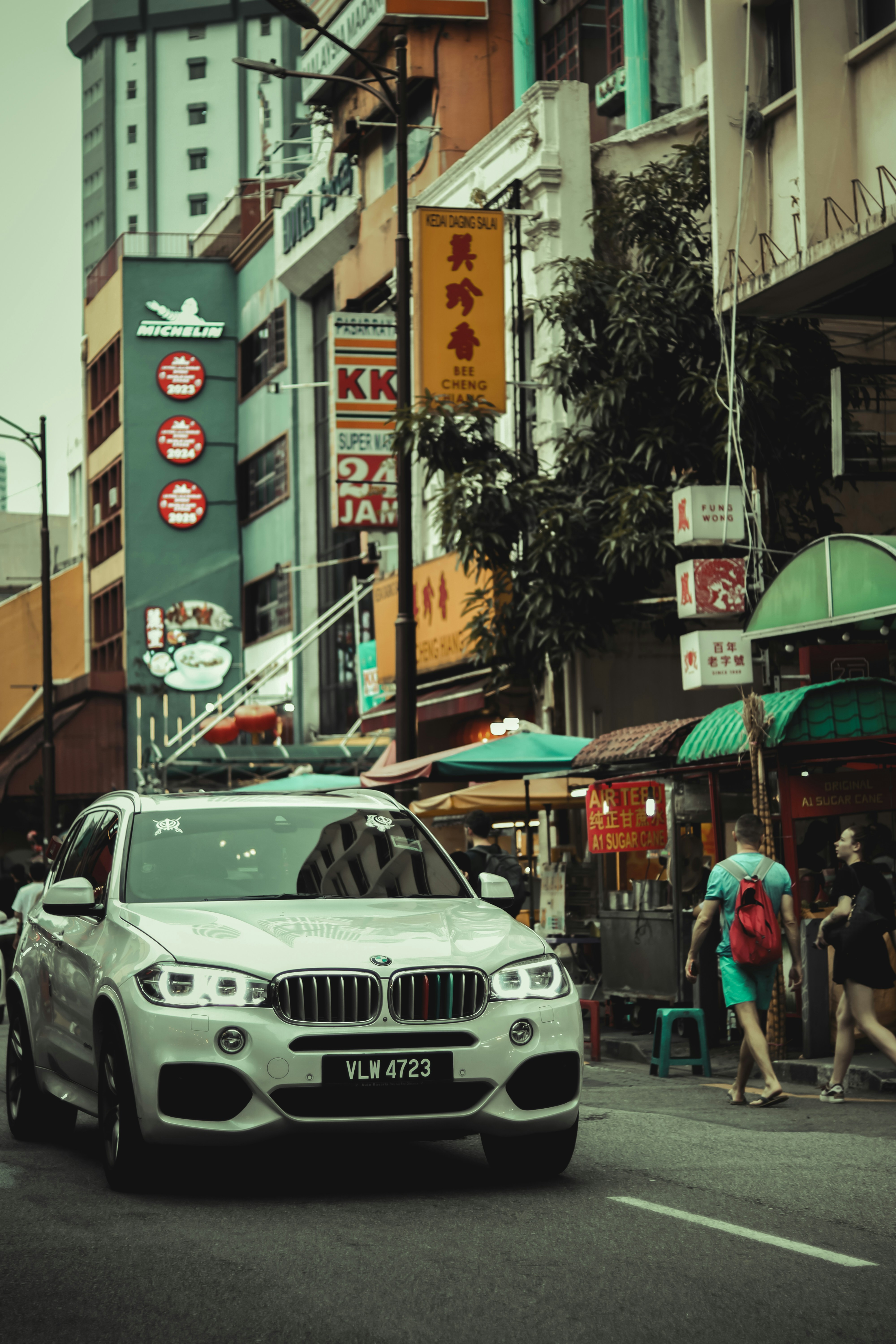 Une BMW roule dans une rue animée de la ville.