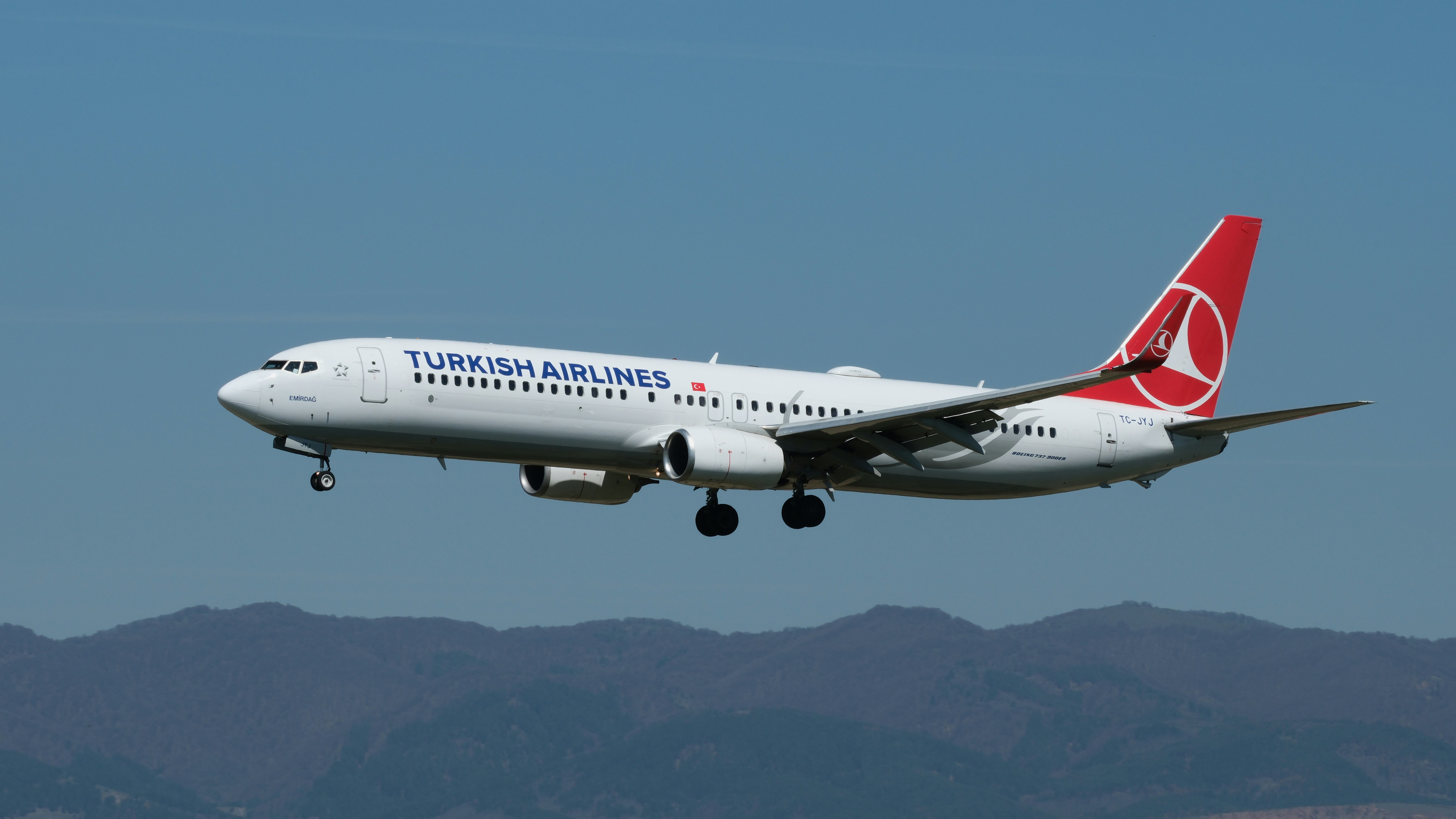 A turkish airlines plane is flying in the sky.