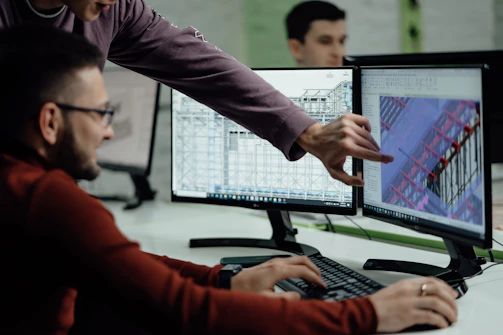 Colleagues collaborate while examining computer designs.