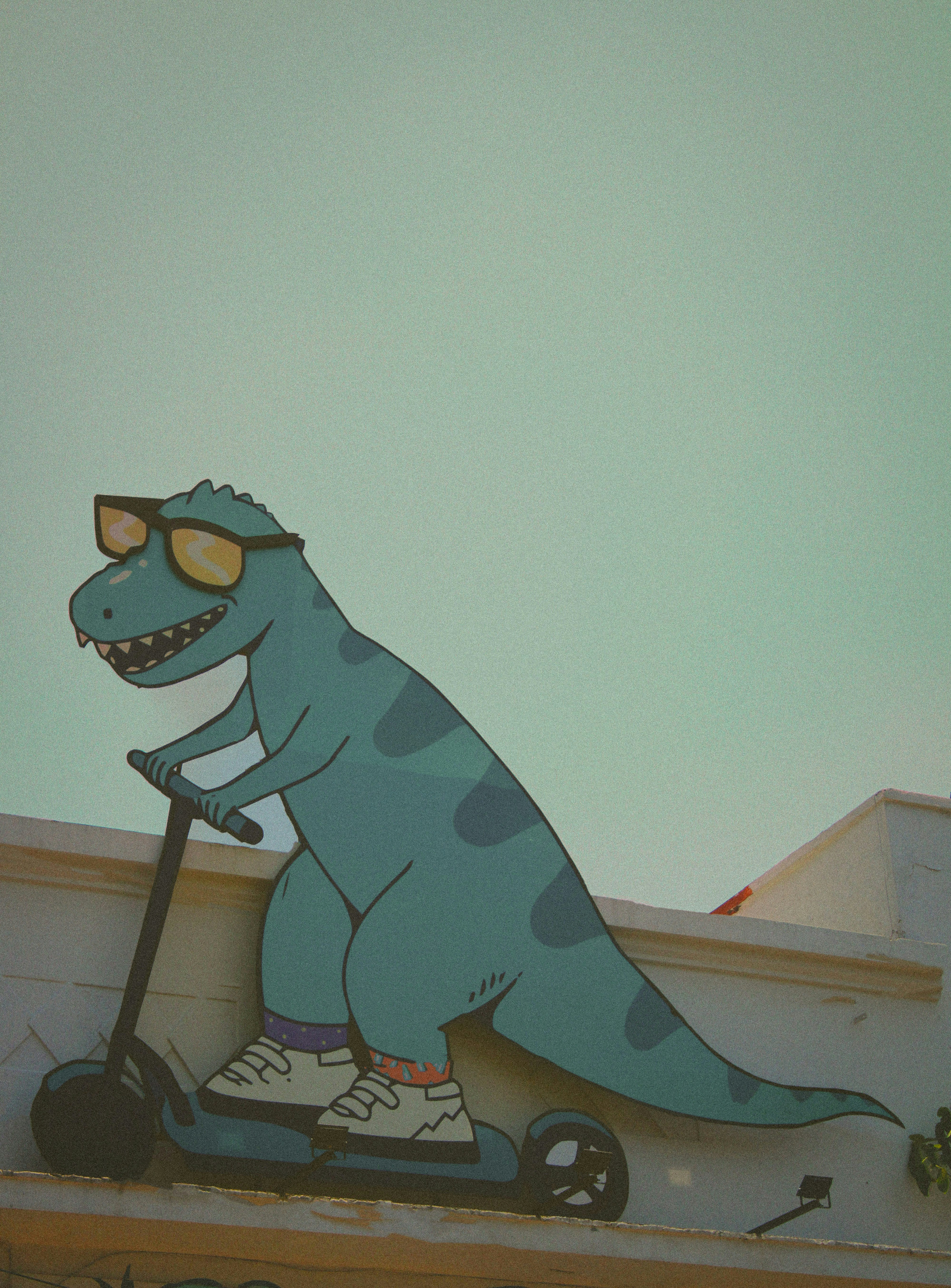 A cool dinosaur rides a scooter.
