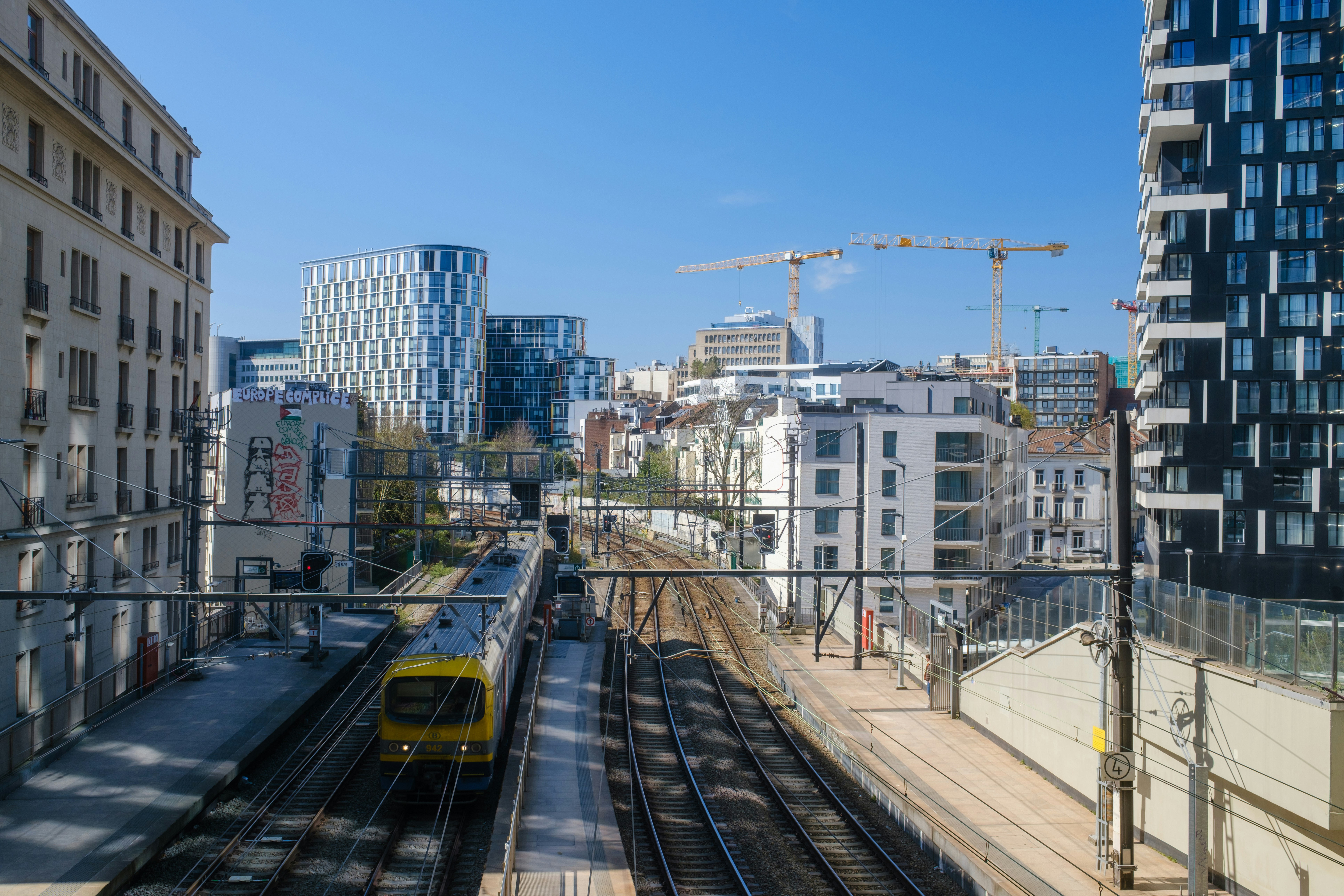 A train travels through the city, with buildings in the background.