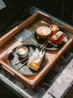 Coffee and pastries on a wooden tray.
