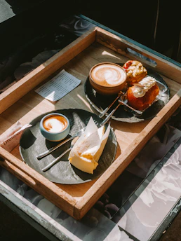 Coffee and pastries on a wooden tray.