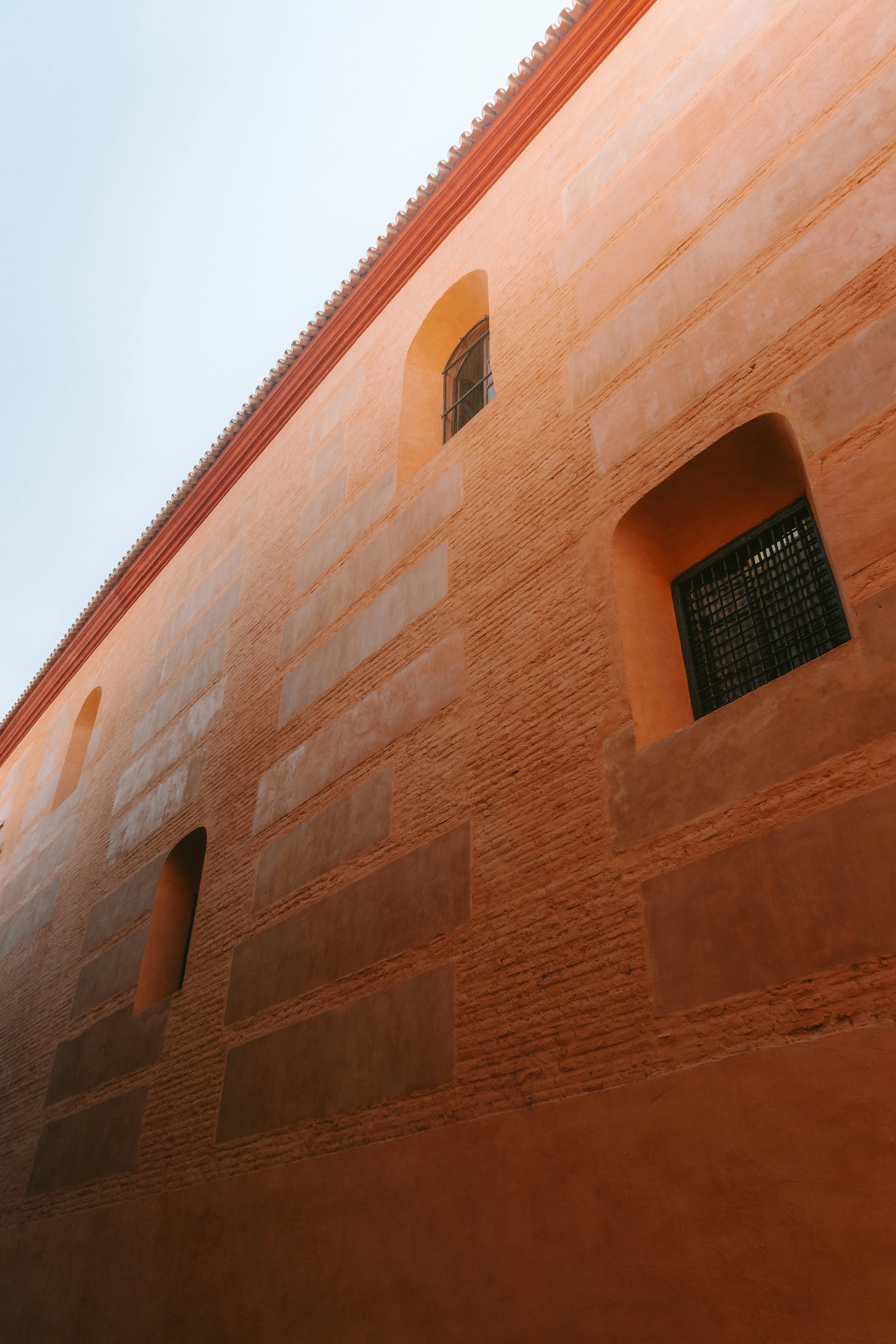 A tall, orange building with small windows.