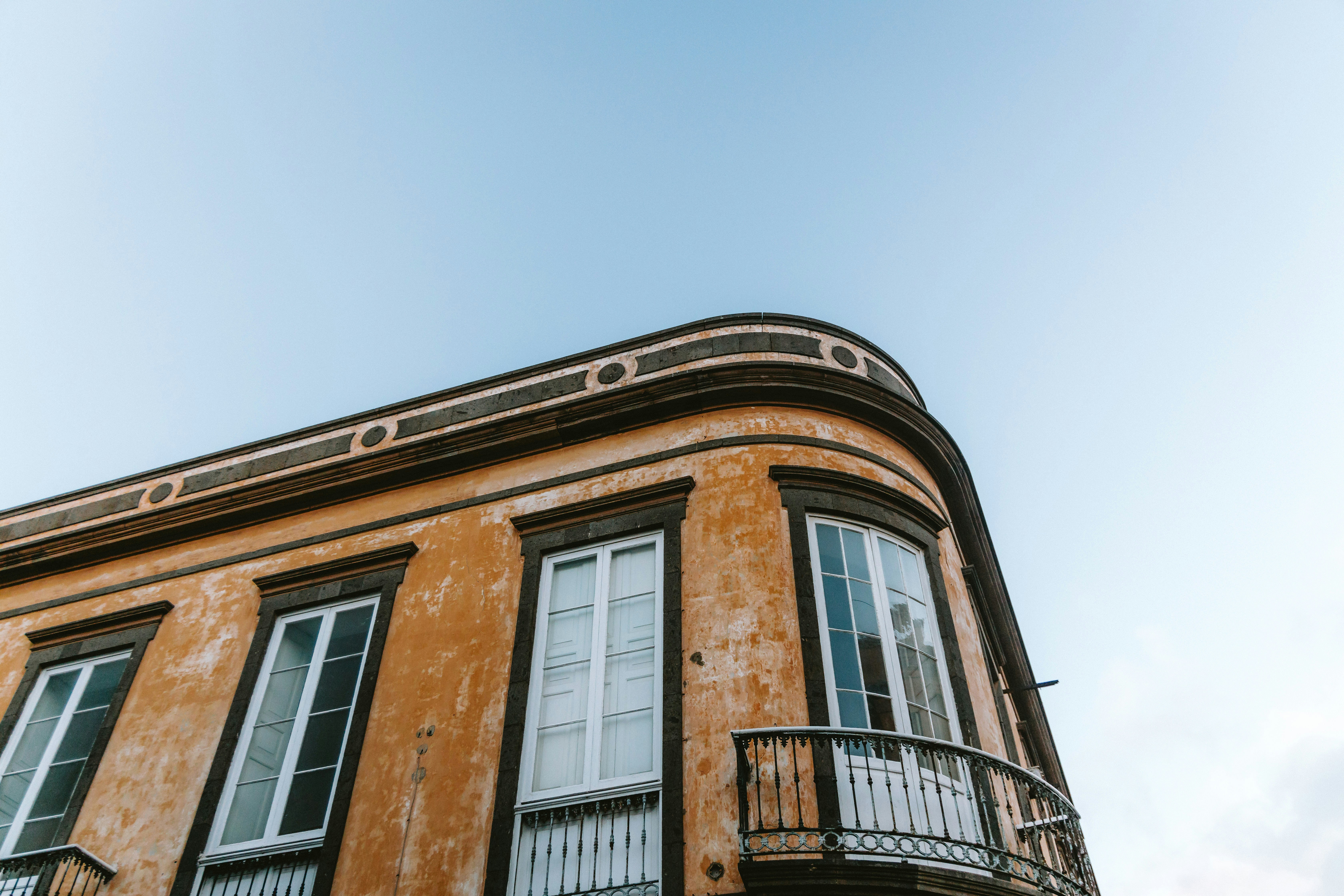 An ornate building with a curved corner and blue sky.