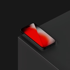 A black phone with a red screen.
