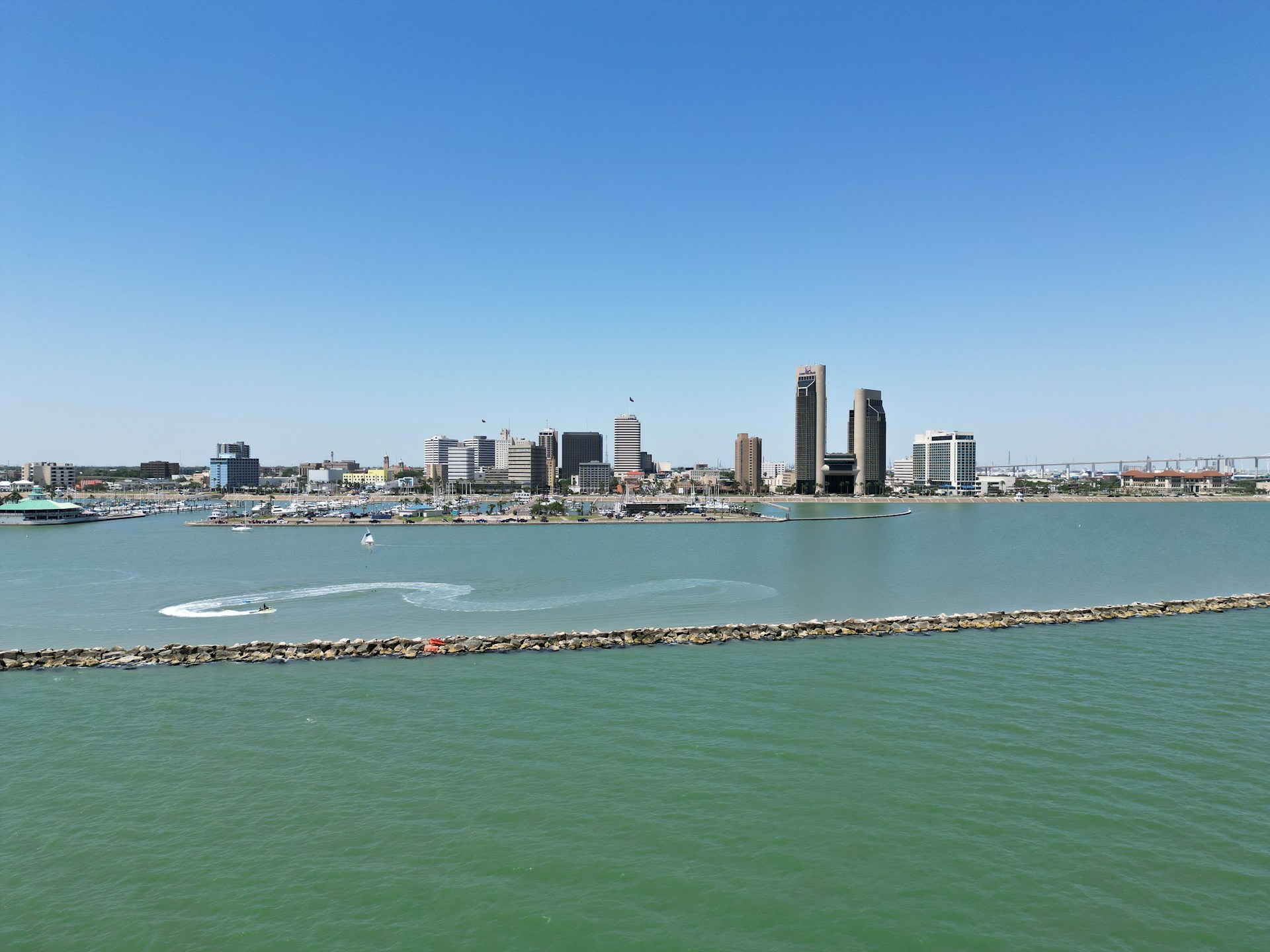 A city skyline is seen across the water.