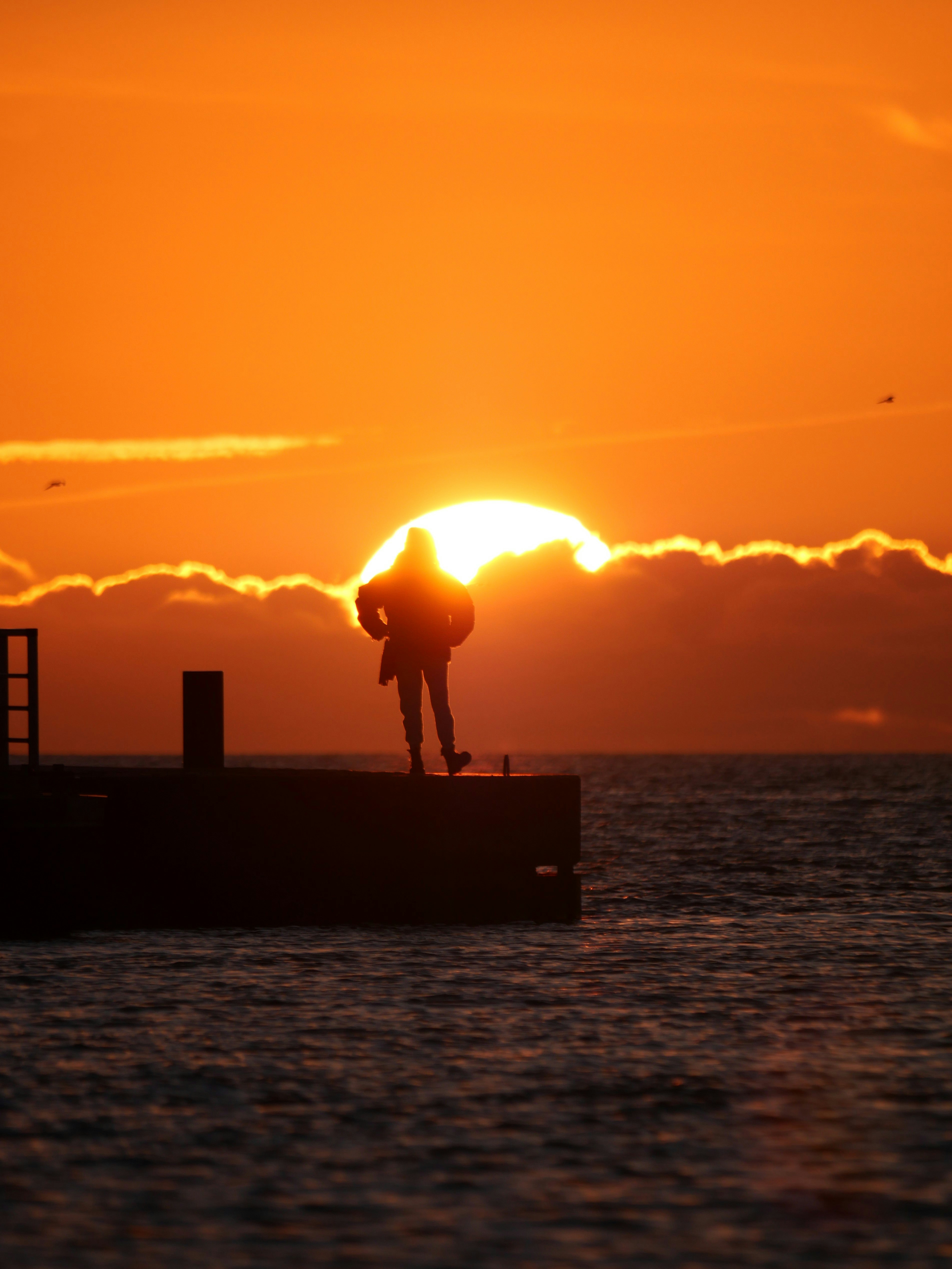 A person silhouetted by a stunning sunset.