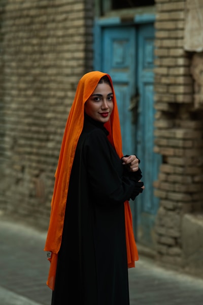 A woman poses, wearing a burqa and headscarf.