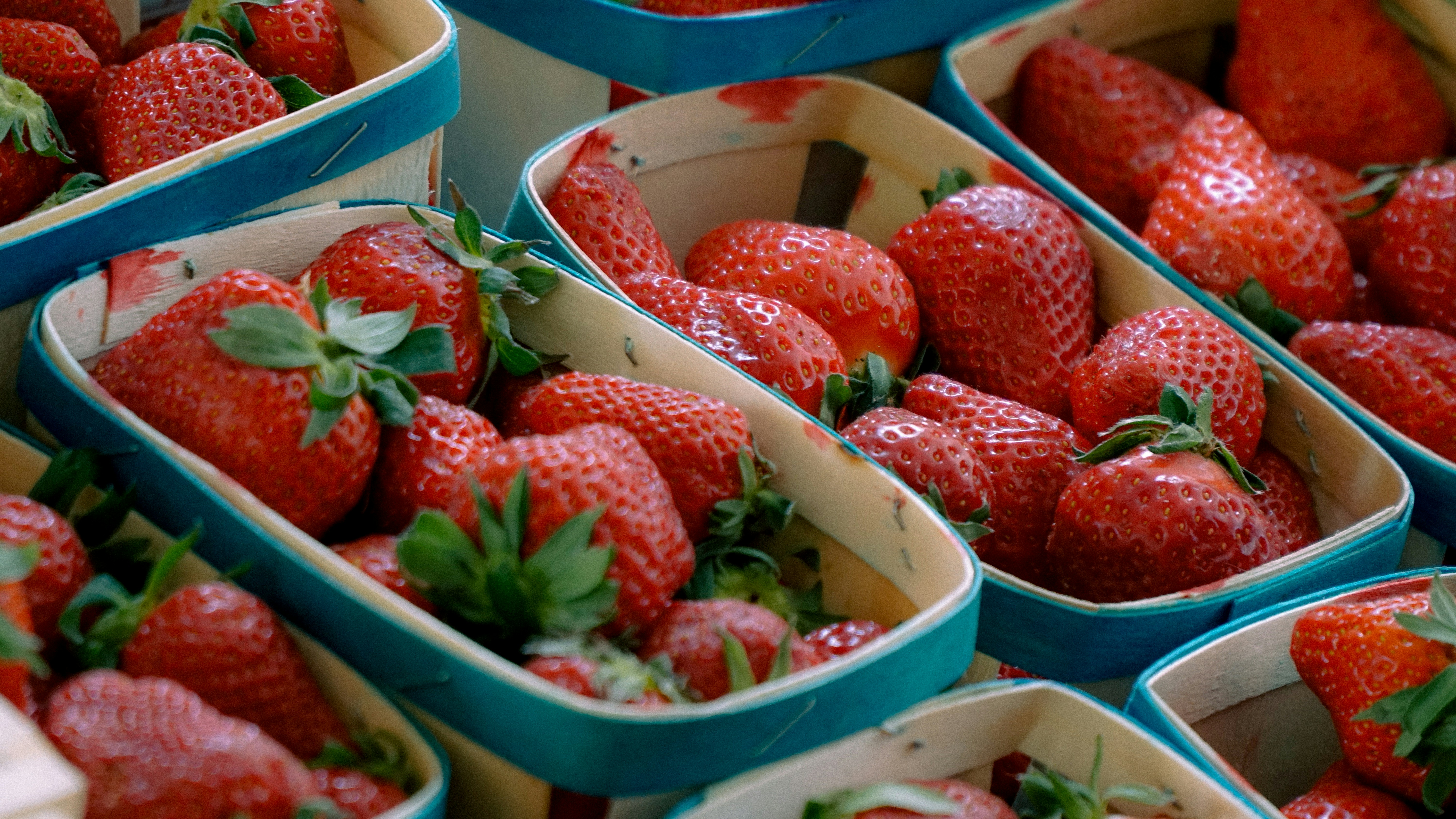 Fresh strawberries in their market baskets.