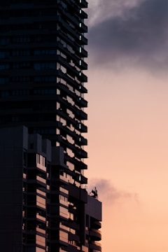 Tall building silhouetted against a sunset sky.